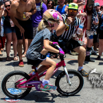 Crowd cheering, young girl on single speed bike riding cry baby hill